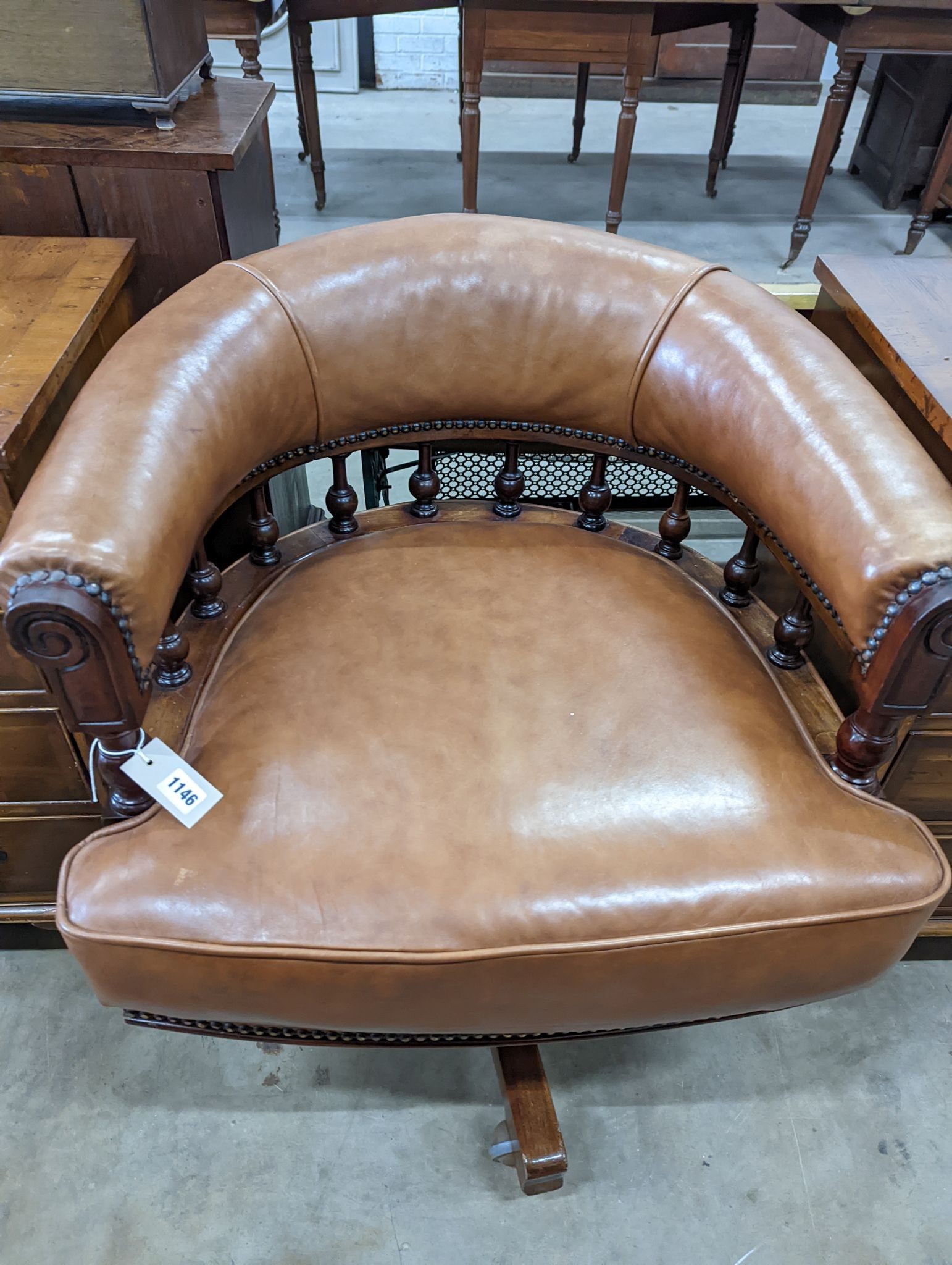 A late Victorian mahogany and tan leather swivel desk chair, width 68cm, depth 63cm, height 77cm